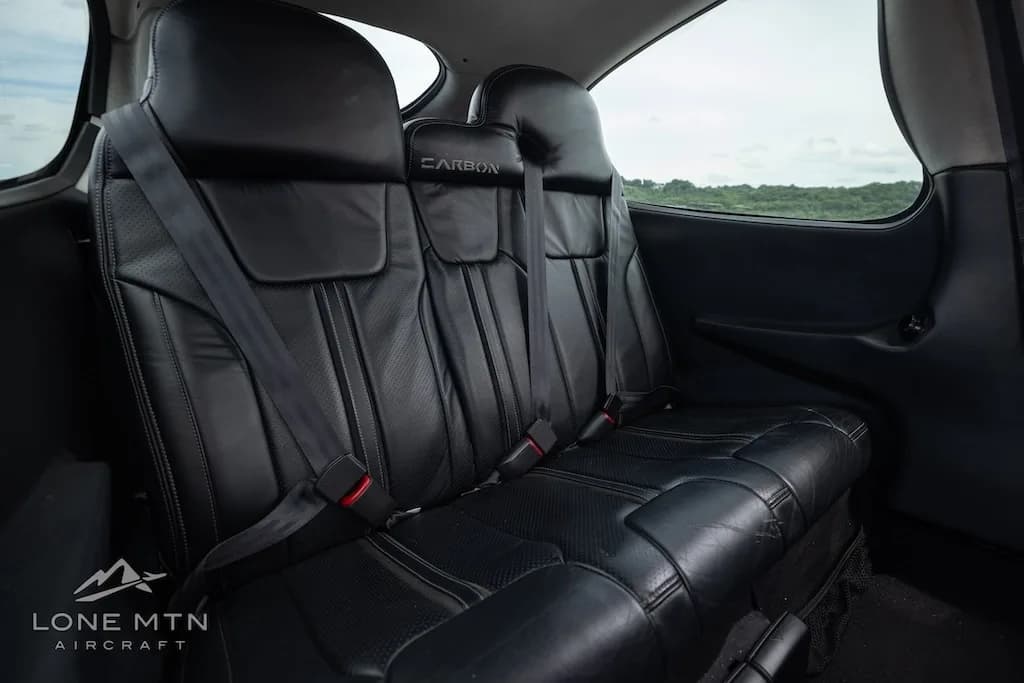 A side view of the black leather rear passenger seats in the Cirrus SR22T Carbon aircraft.