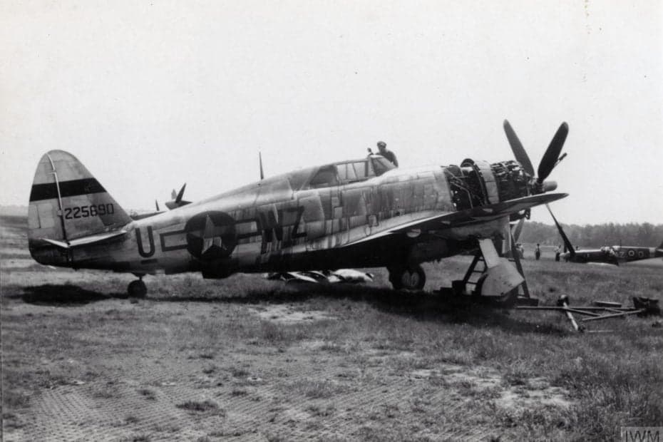 A black and white photo of a Republic P-47 Thunderbolt on a grassy field.