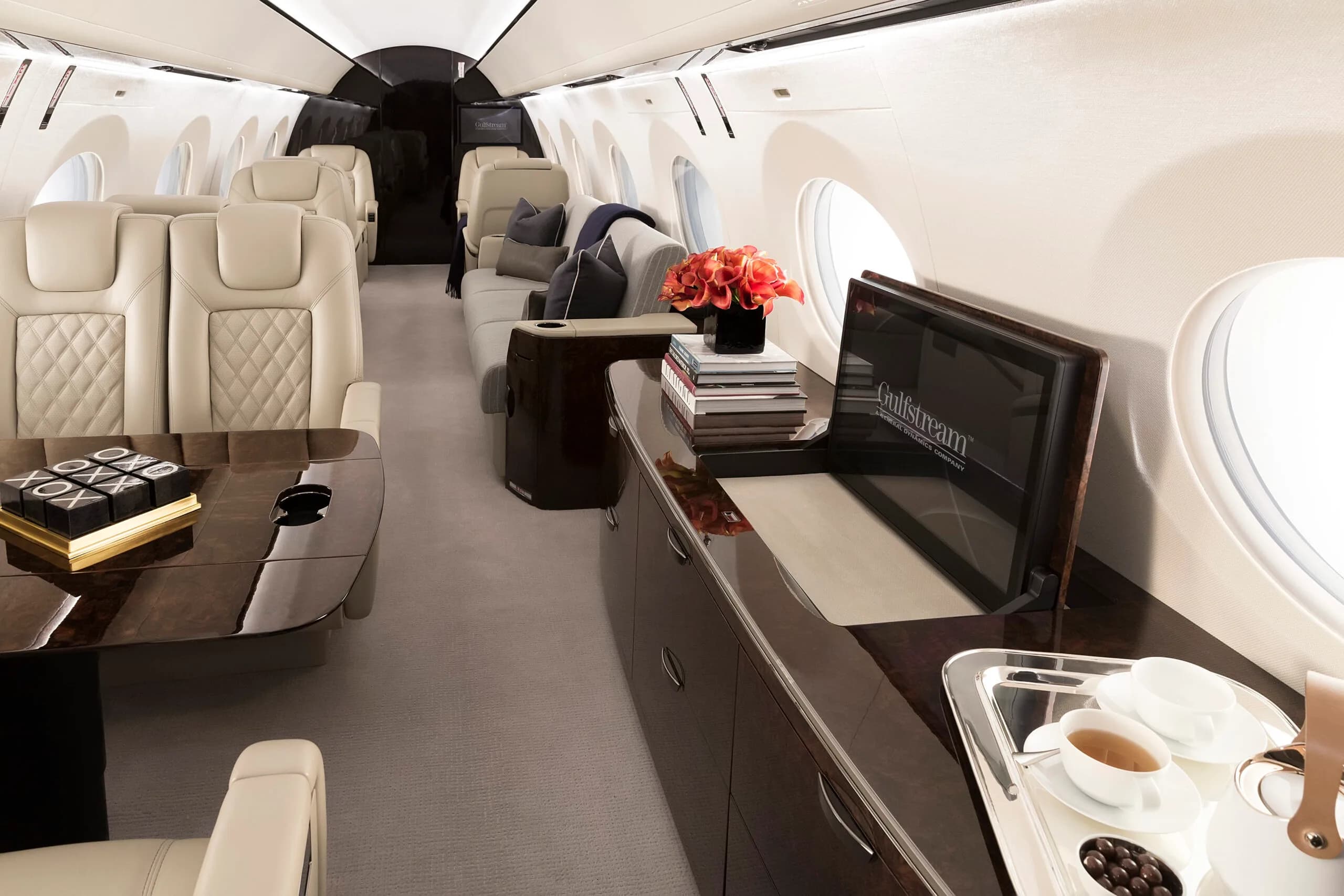 Luxurious interior of a Gulfstream jet with leather seats and wood trim.