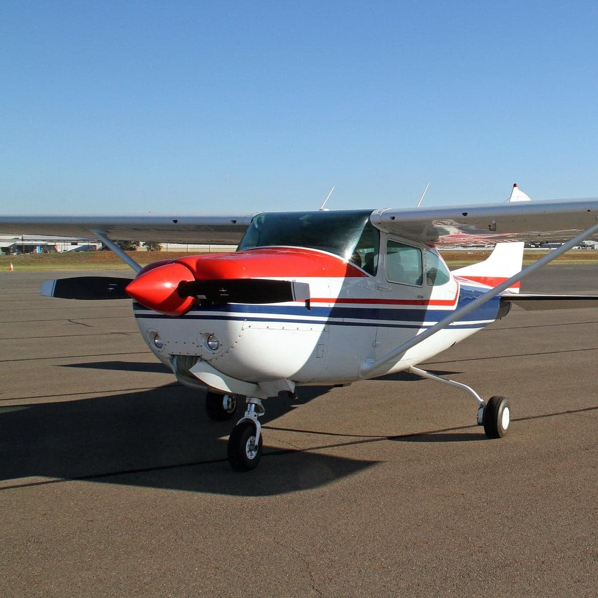 Front quarter view of the aircraft on the tarmac with a red, white, and blue paint scheme.