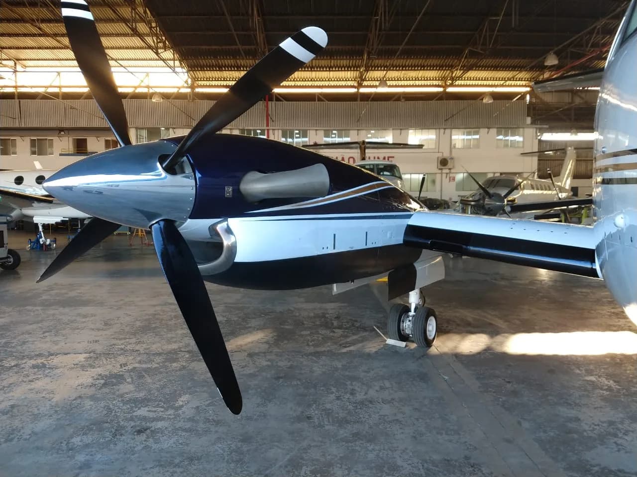Close up of the propeller and engine cowling of a Beechcraft King Air 200 inside a hangar.