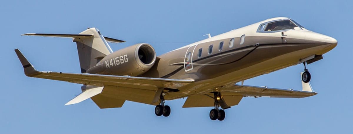 A Learjet 45XR, registration N415SG, is shown in flight with its landing gear down.