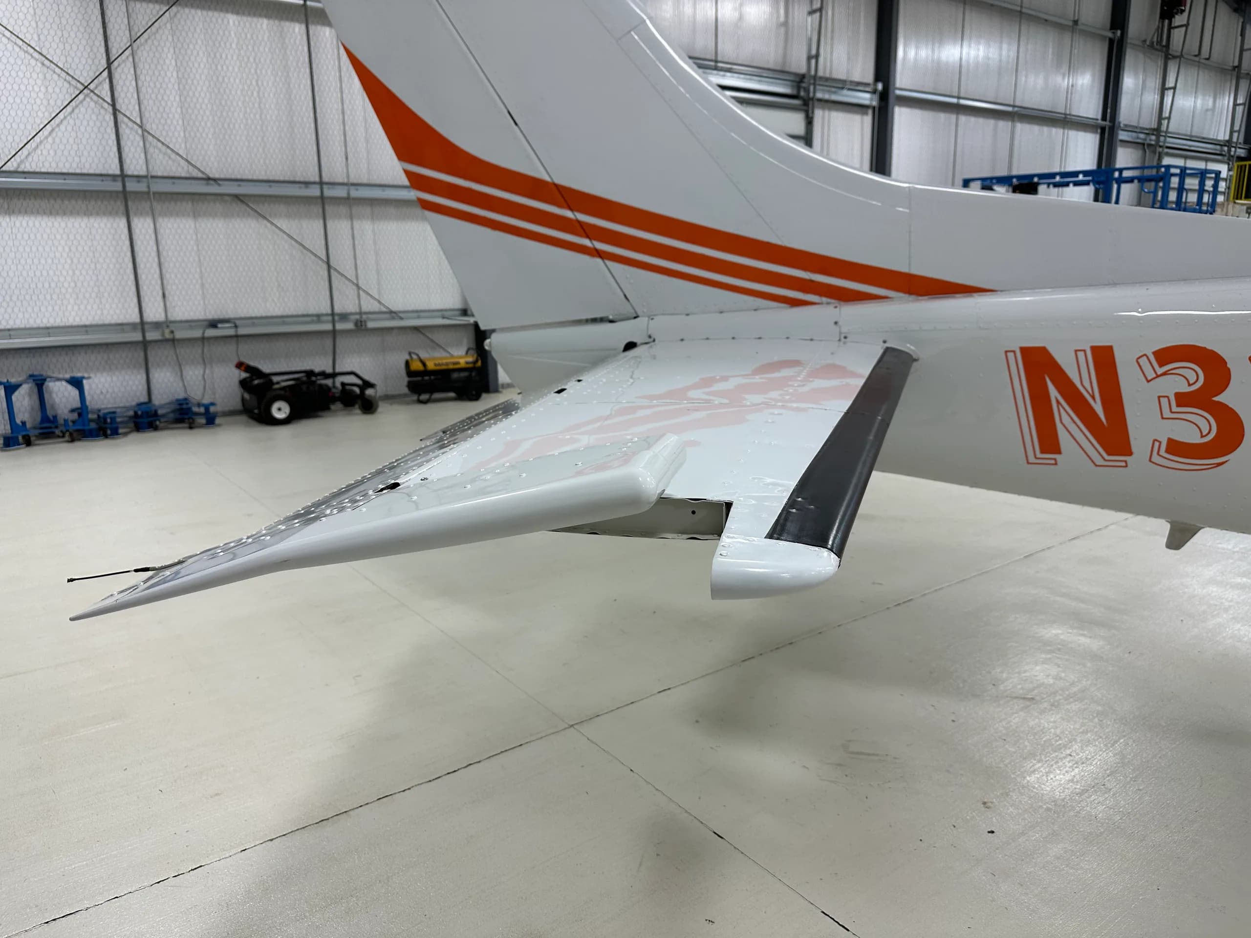 The tail section of a Cessna 206 Stationair aircraft with orange stripes.