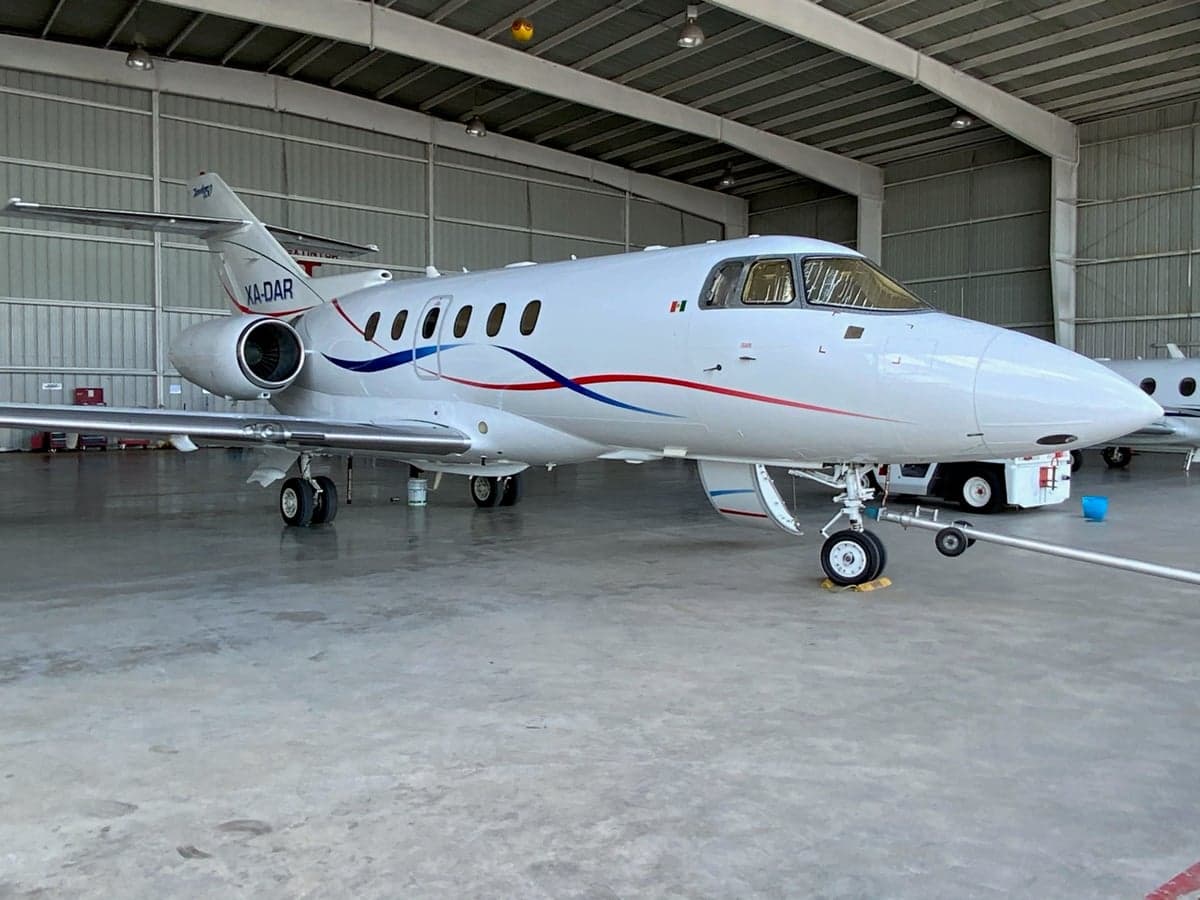 XA-DAR Falcon 50 parked in a hangar, front quarter view.