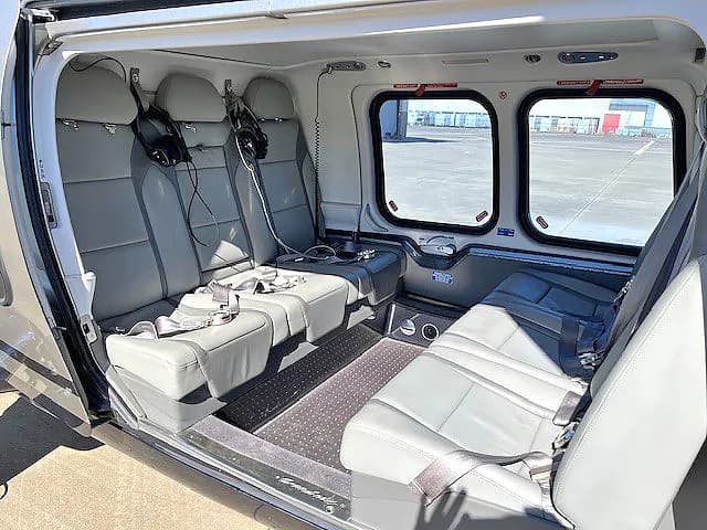 Interior view of the helicopter cabin with gray leather seats.