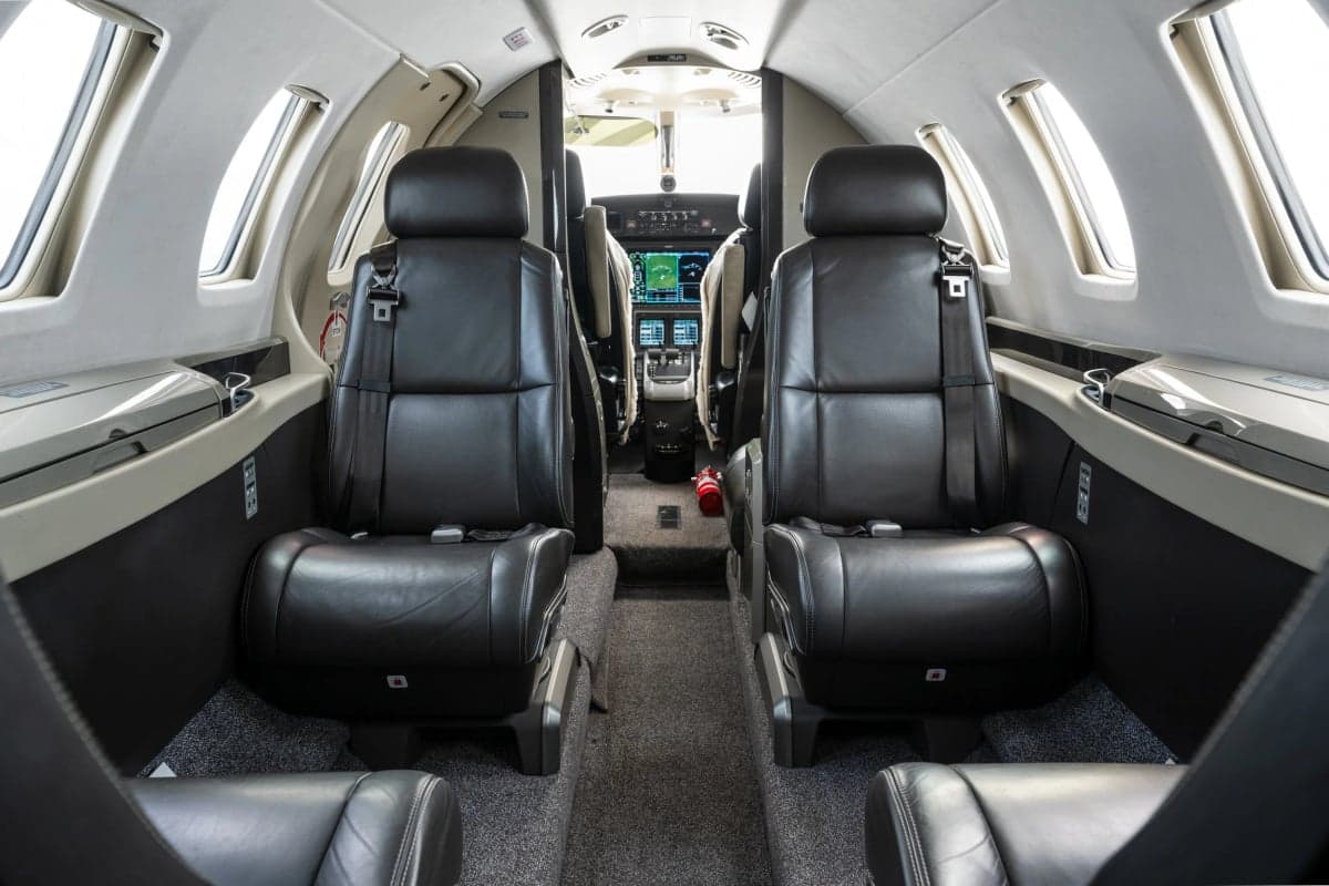 View of the aircraft's cabin with black leather seats.