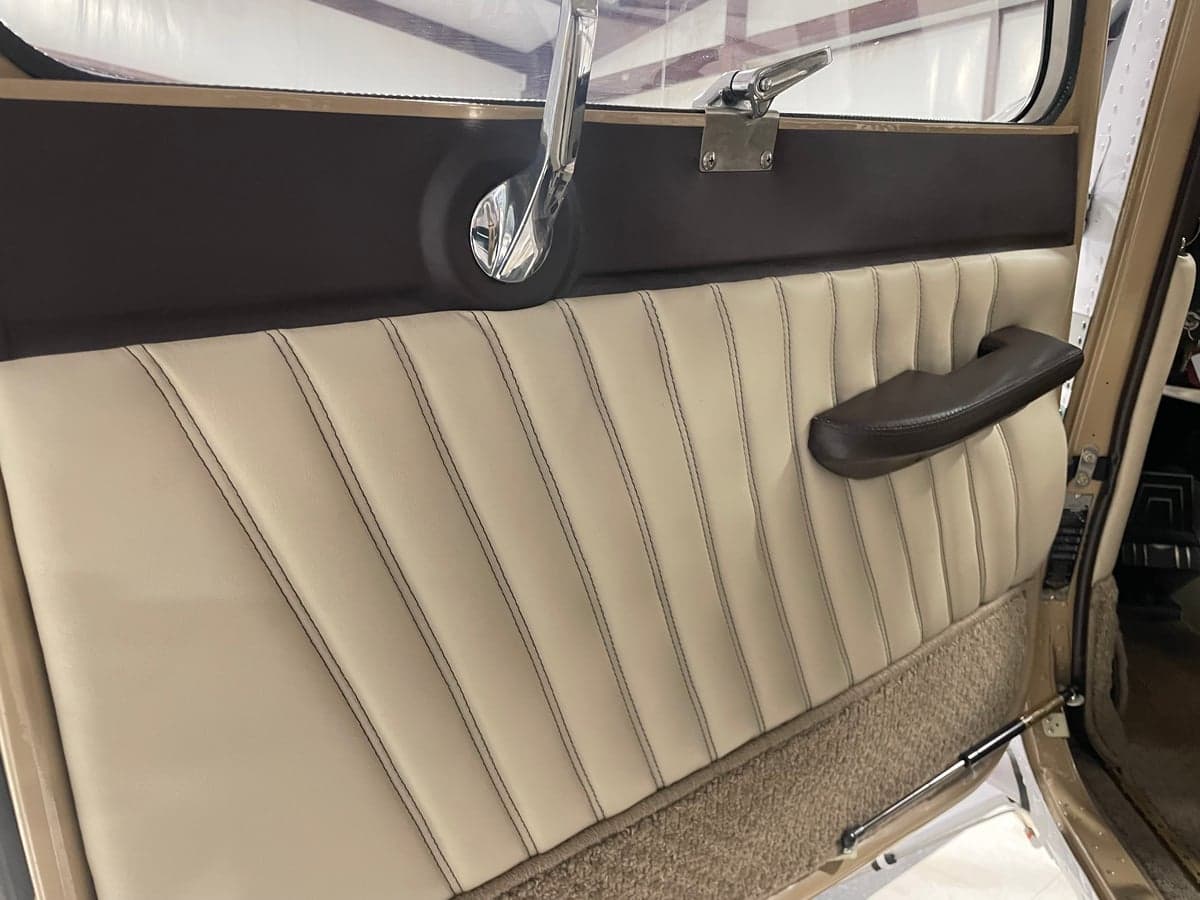 Interior side panel of the Cessna 185 Skywagon with light colored upholstery.