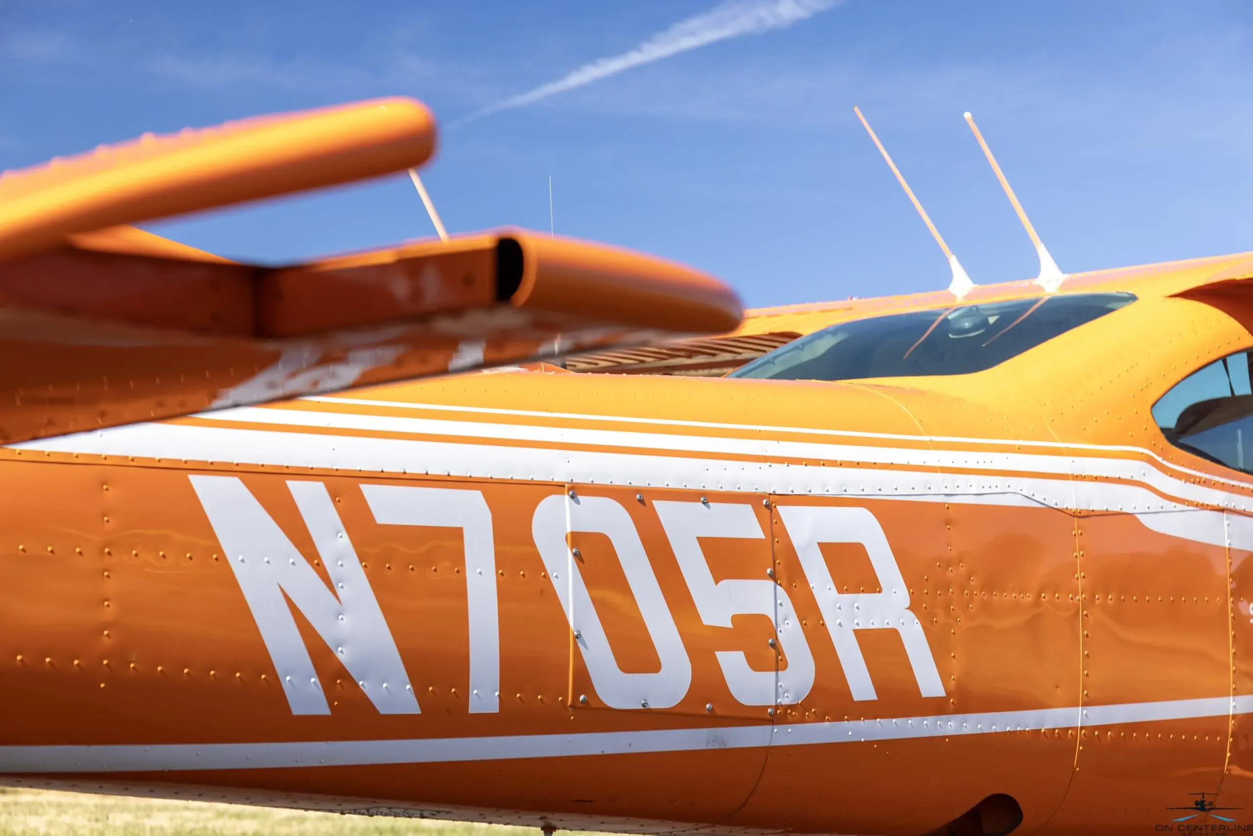Close-up of the tail number N705R on the orange and white Cessna 182 Skylane RG.