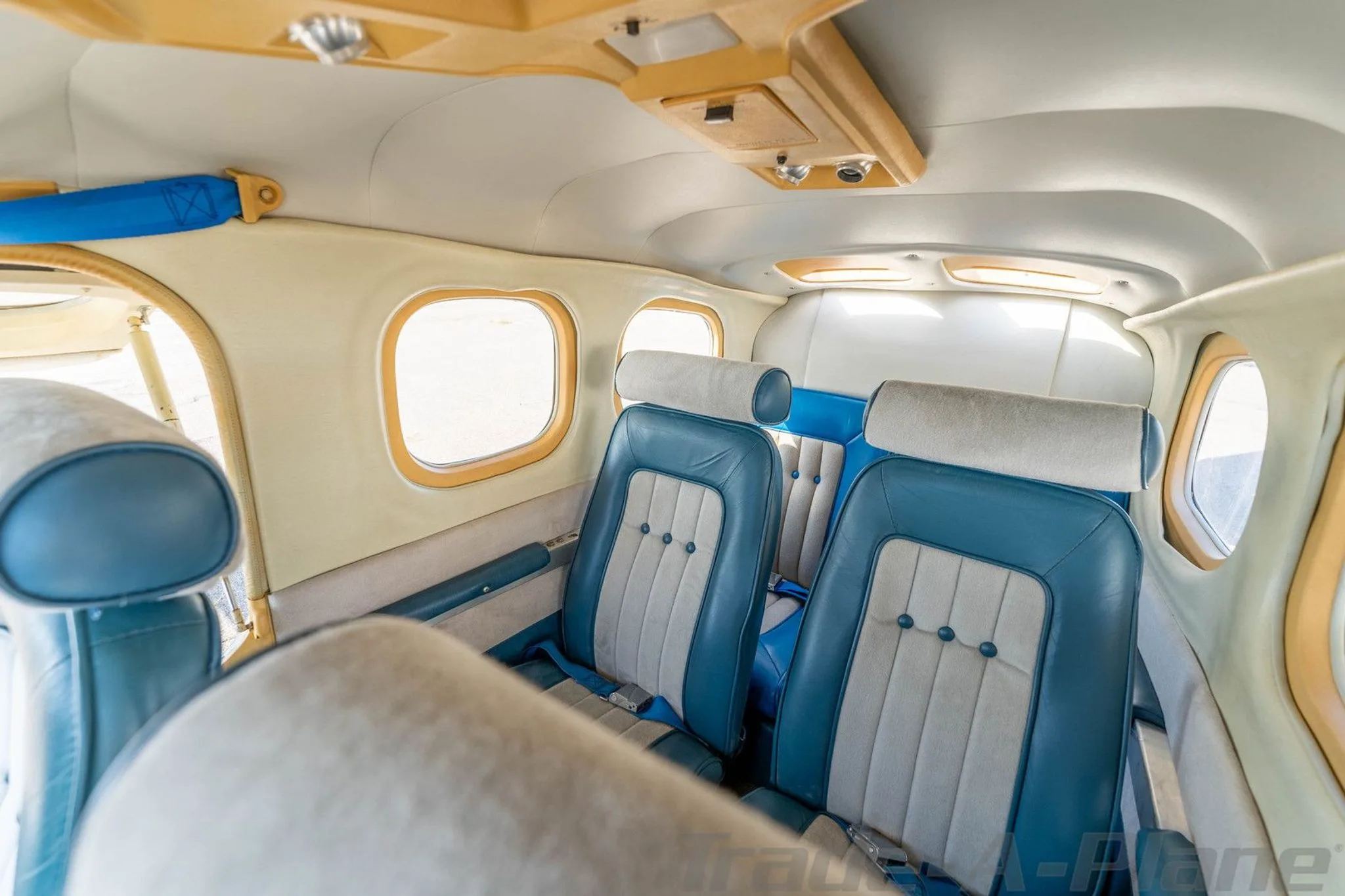 The aircraft's cabin interior features blue and light gray seats with light tan trim around the windows.