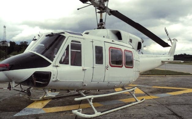 A white Bell 212 helicopter on a helipad.