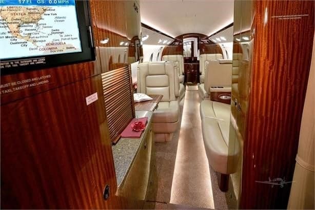 View of the aircraft's interior, featuring wood paneling and leather seats.
