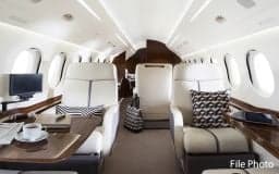 Interior of the Falcon jet with comfortable seating and a table.