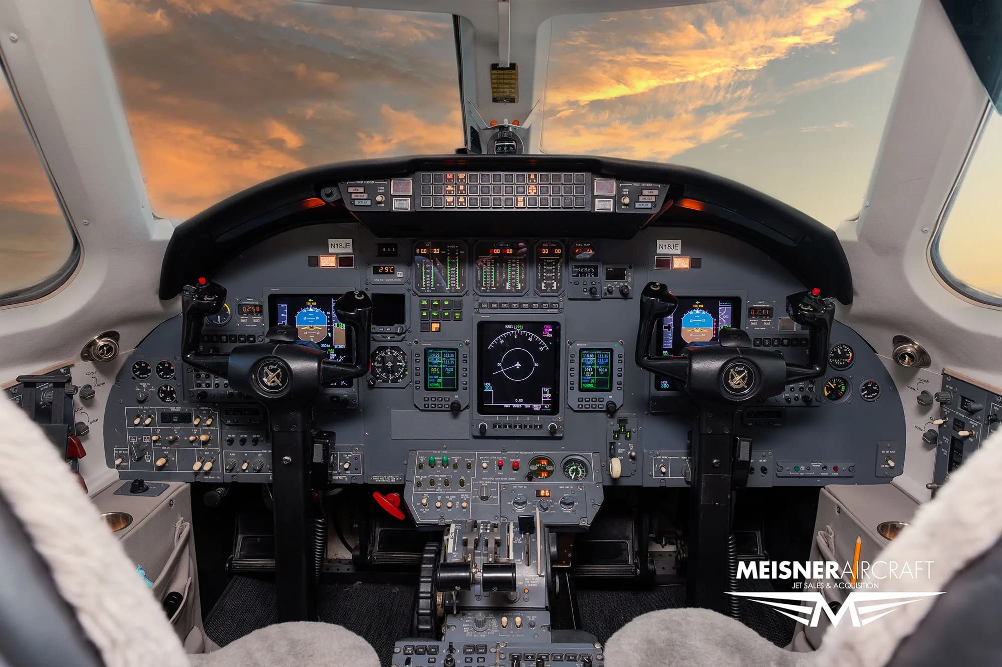 The cockpit of a Citation Excel business jet with multiple digital displays and controls, viewed from the pilot's seat.