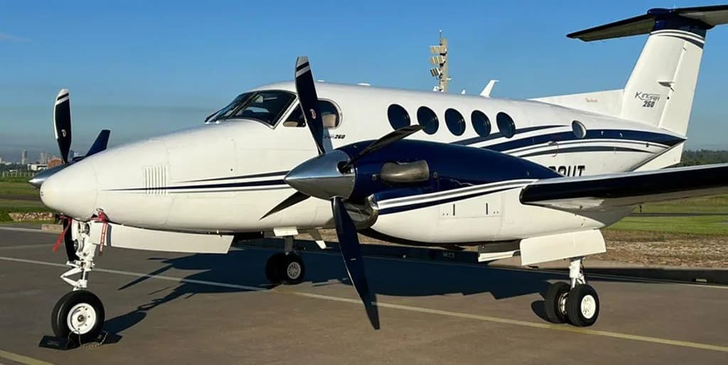 A close-up front-left view of the N260UT King Air 260 aircraft with its white and dark blue paint scheme.