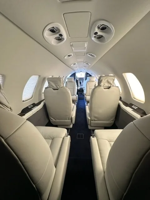 View of the aircraft cabin with white leather seats.