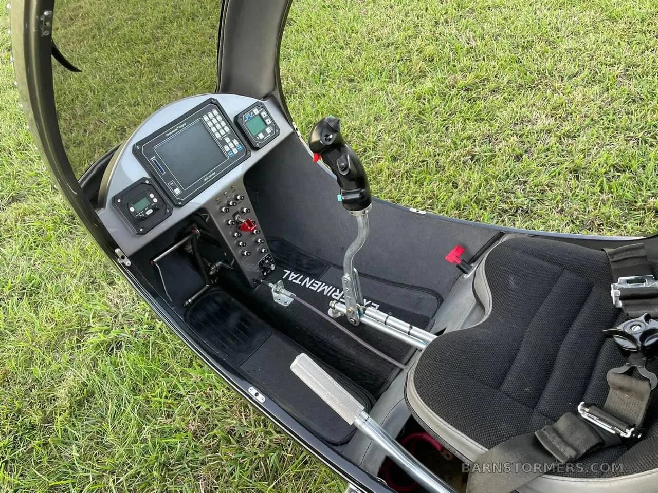 A close-up view of the helicopter's cockpit shows the instrument panel with screens and various controls.