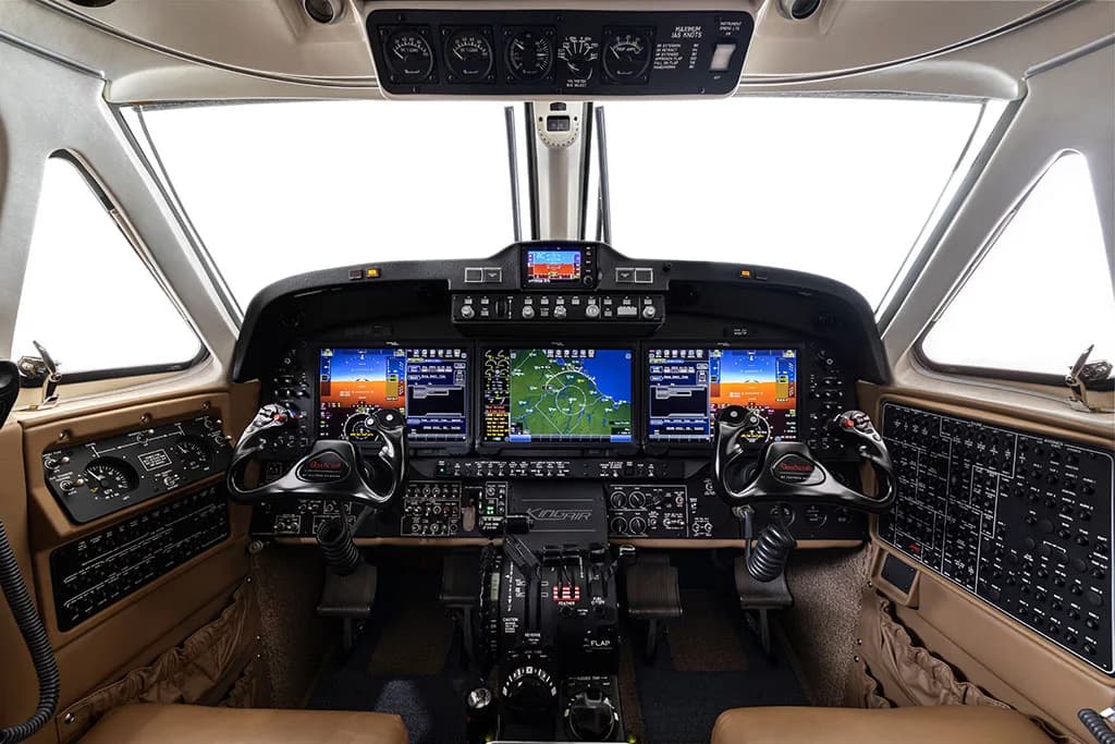 The aircraft's modern cockpit with multiple digital displays, yokes, and control panels.