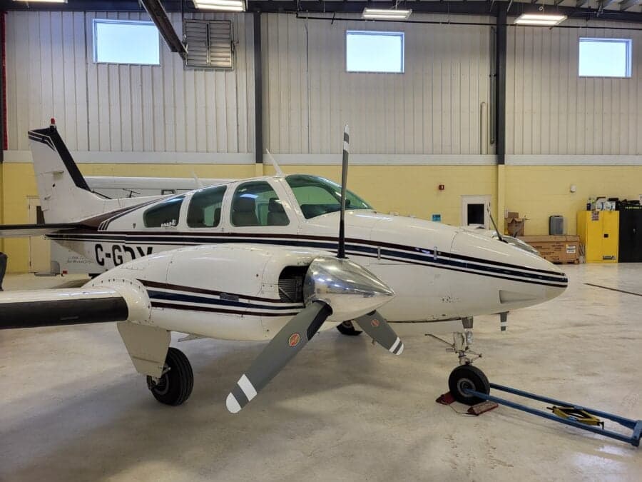 A Beechcraft Baron sits in a hangar.