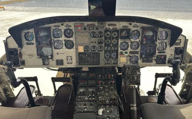 The helicopter's cockpit featuring a detailed view of the instrument panel and controls.