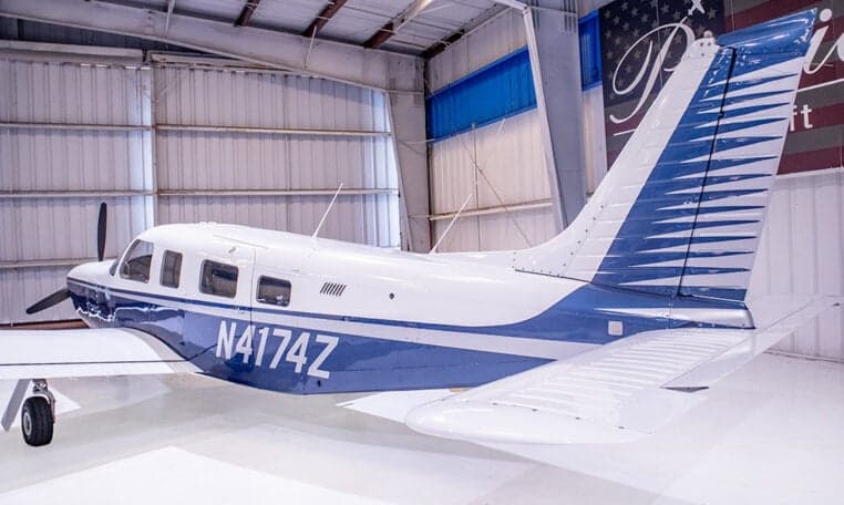 Piper PA-28-181 Archer II aircraft with blue and white paint scheme in a hangar, registration N4174Z.