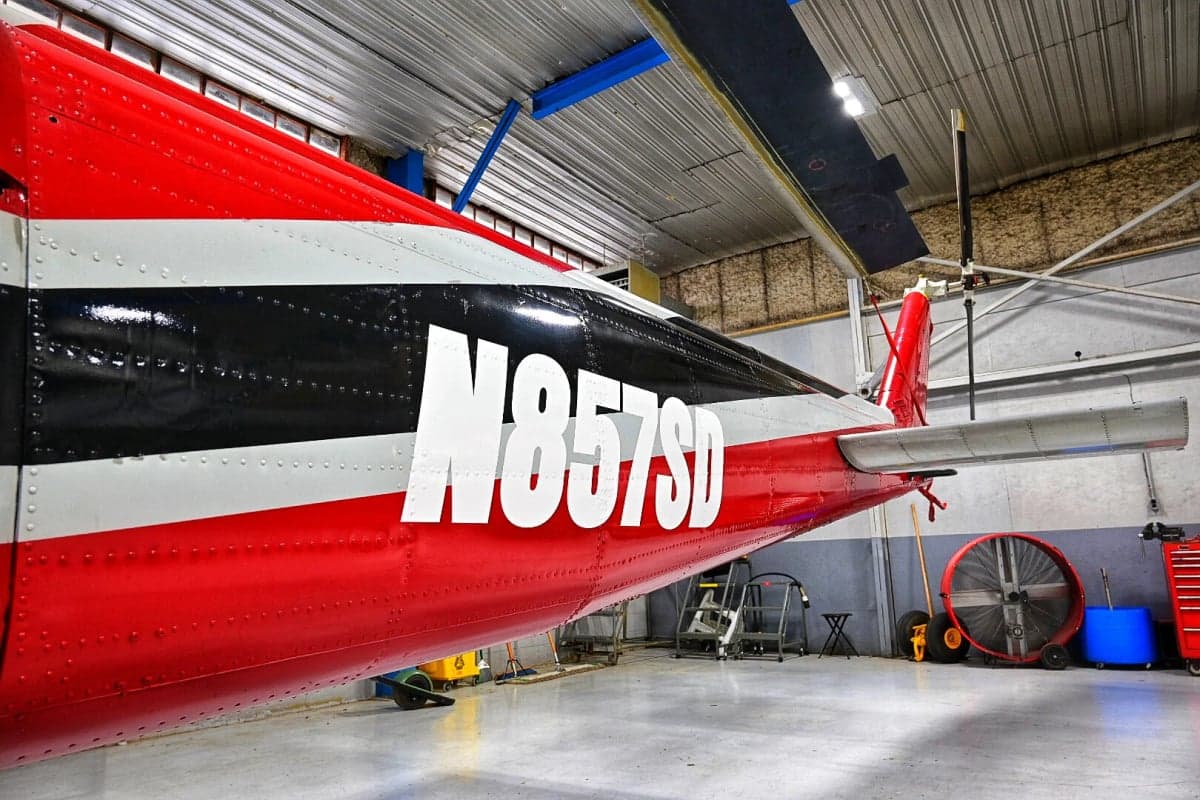 Tail section of the N857SD helicopter in a hangar.