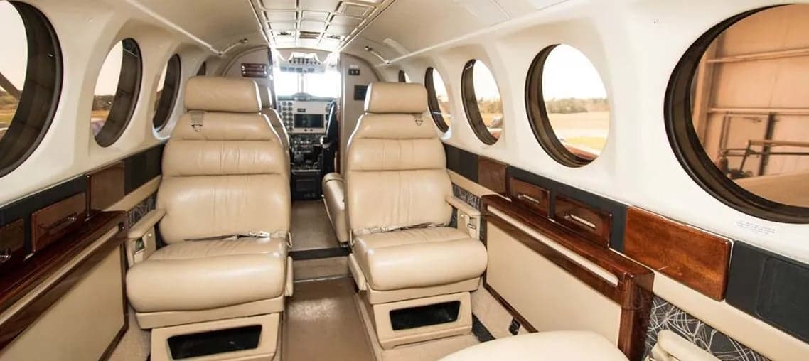 Interior view of the Beechcraft King Air 200 cabin with leather seats and wood accents.