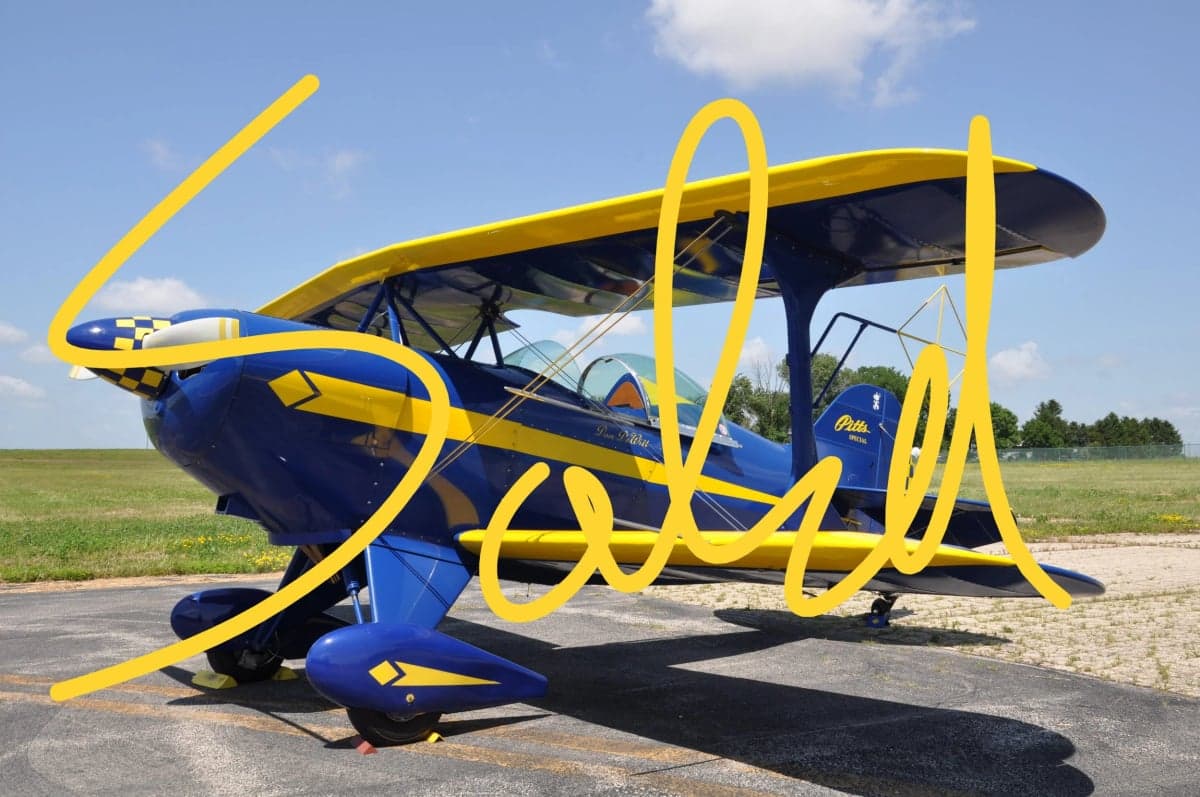 A blue and yellow biplane with the word SOLD overlaid on the image.