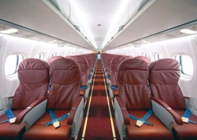 The interior cabin of an ATR 42 aircraft with red seats.