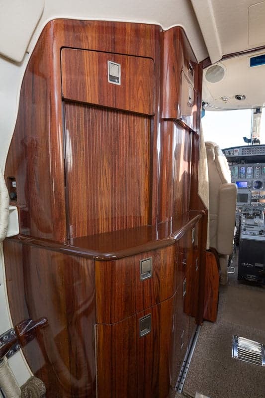Interior view of the aircraft cabin with wood cabinetry.