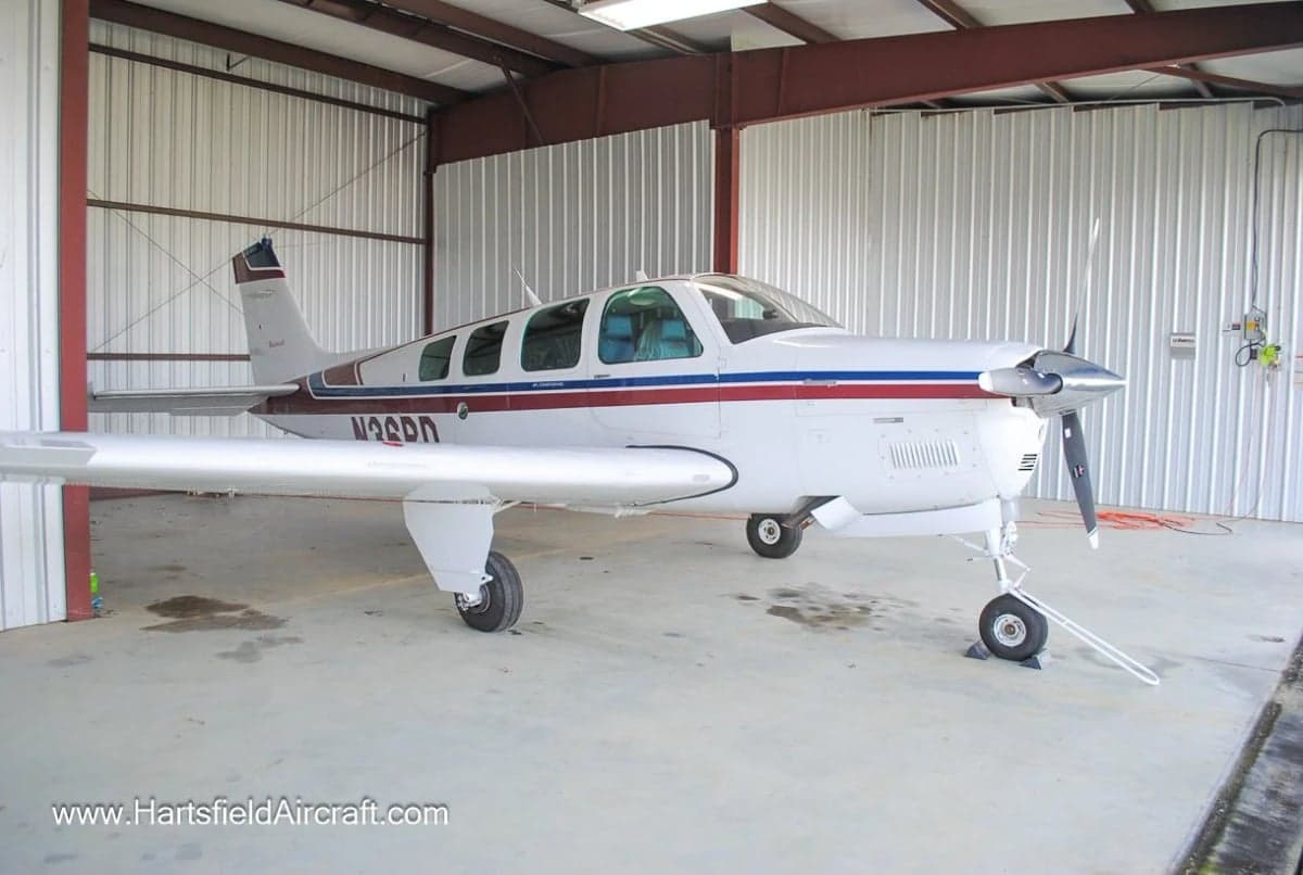 Front view of a Beechcraft Bonanza aircraft inside a hangar.