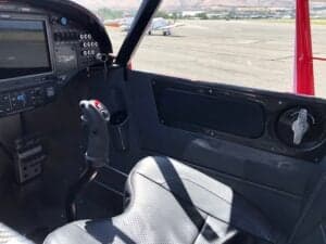 The cockpit of a Cubcrafters aircraft, showing the control stick and instrument panel.