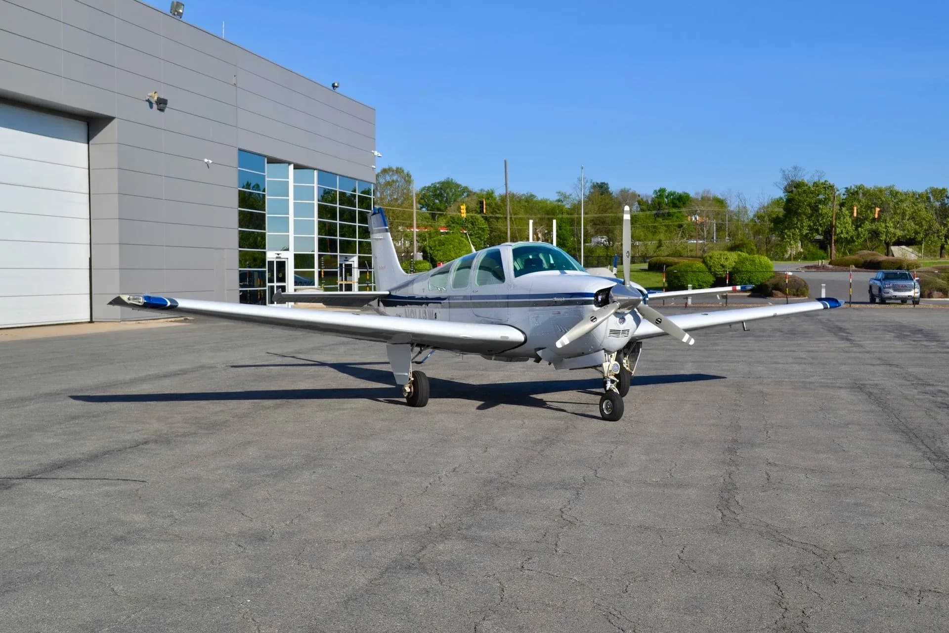 Beechcraft Bonanza N8142W parked on the tarmac in front of a building.
