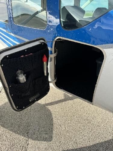 Close-up of the open baggage compartment door of a Cessna 182 Skylane aircraft.