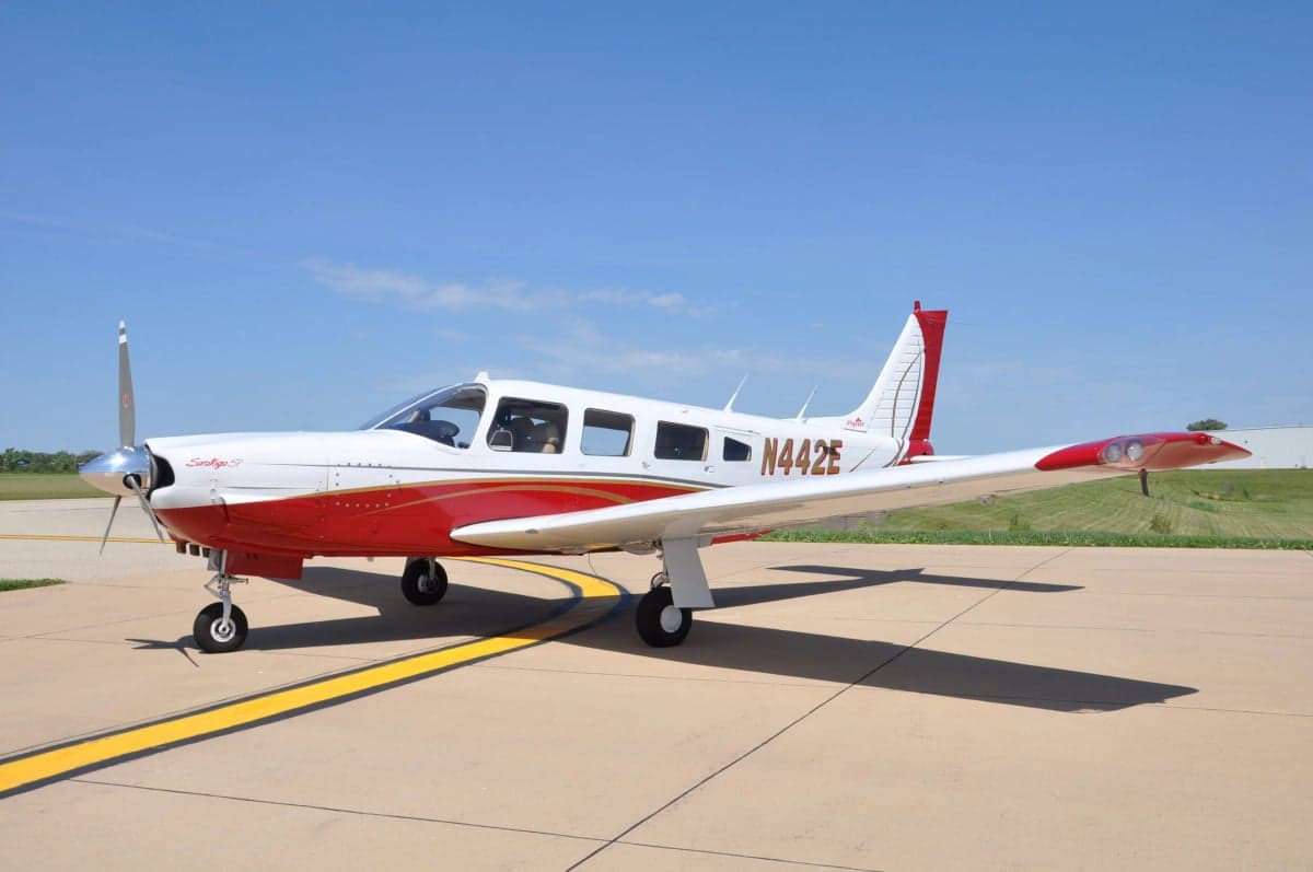 Piper Saratoga with red and white paint scheme on the tarmac.