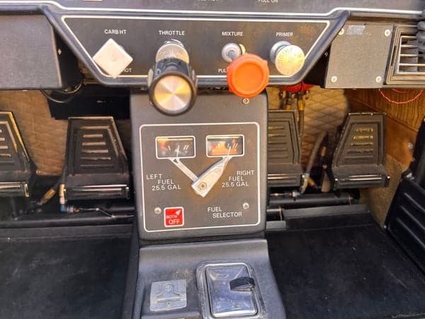 View of the aircraft's throttle, mixture, and fuel selector controls in the cockpit.