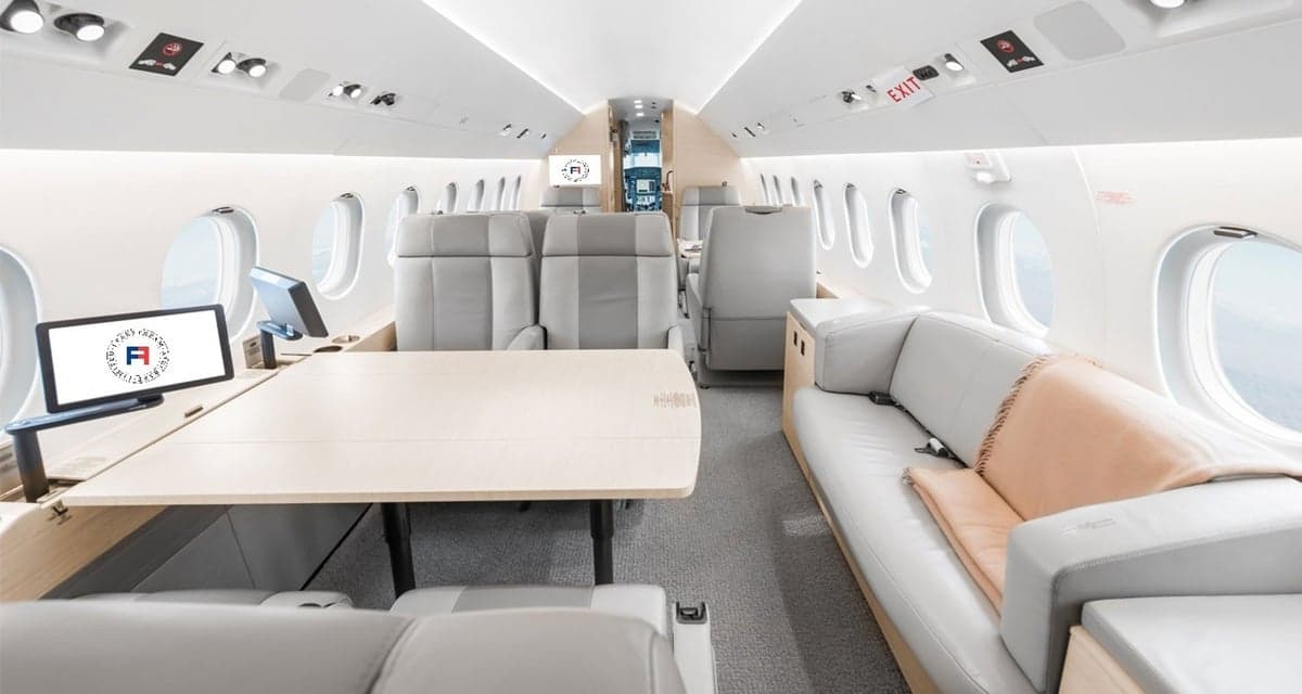 Aircraft interior with light gray seats and a table.