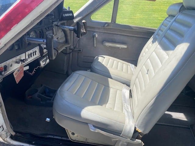 Front seats of a Cessna 177 Cardinal, showing the gray upholstery and cockpit controls.