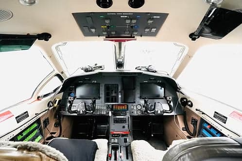 The cockpit of an aircraft features a full instrument panel and controls.