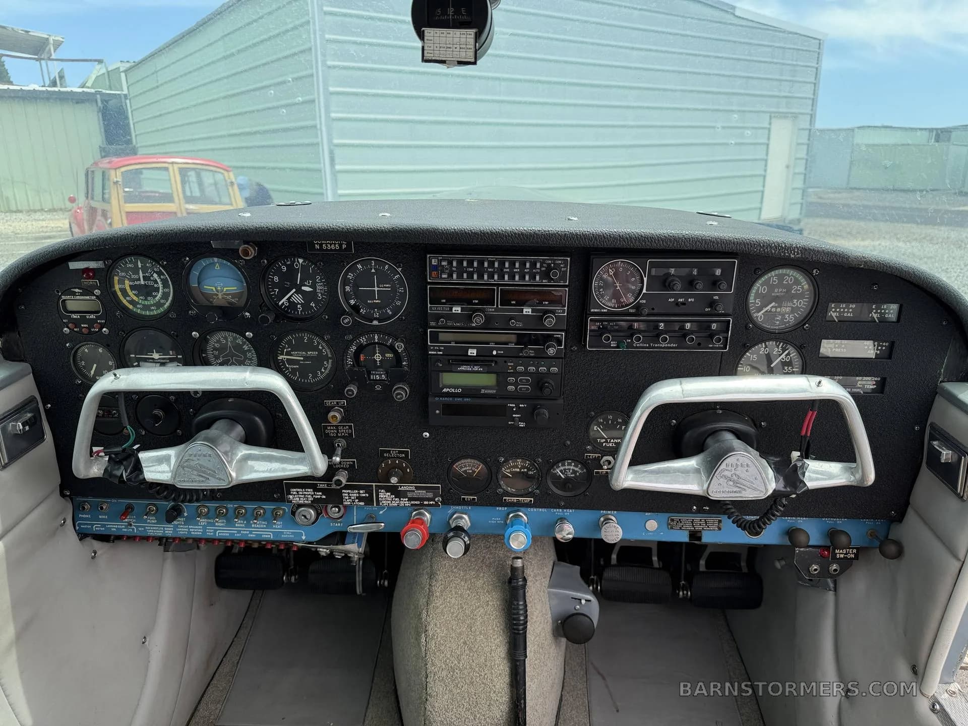 The cockpit of a small aircraft, showing the instrument panel with analog gauges and two control yokes.
