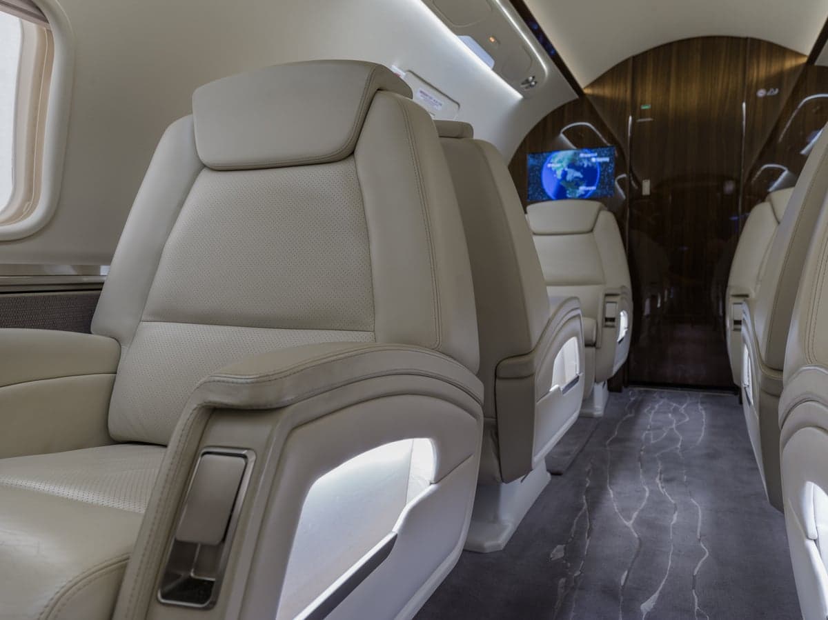 Close-up of white leather seats in the aircraft's interior.