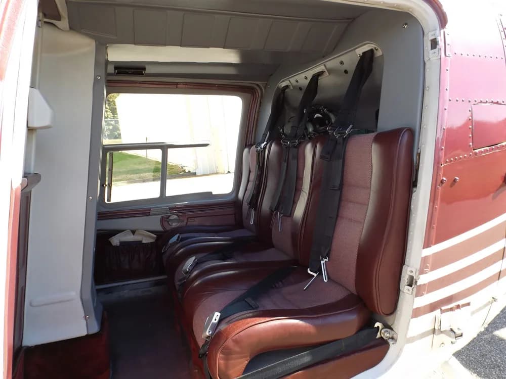 The interior of the Bell 206B JetRanger III shows the rear passenger seats and side panel.