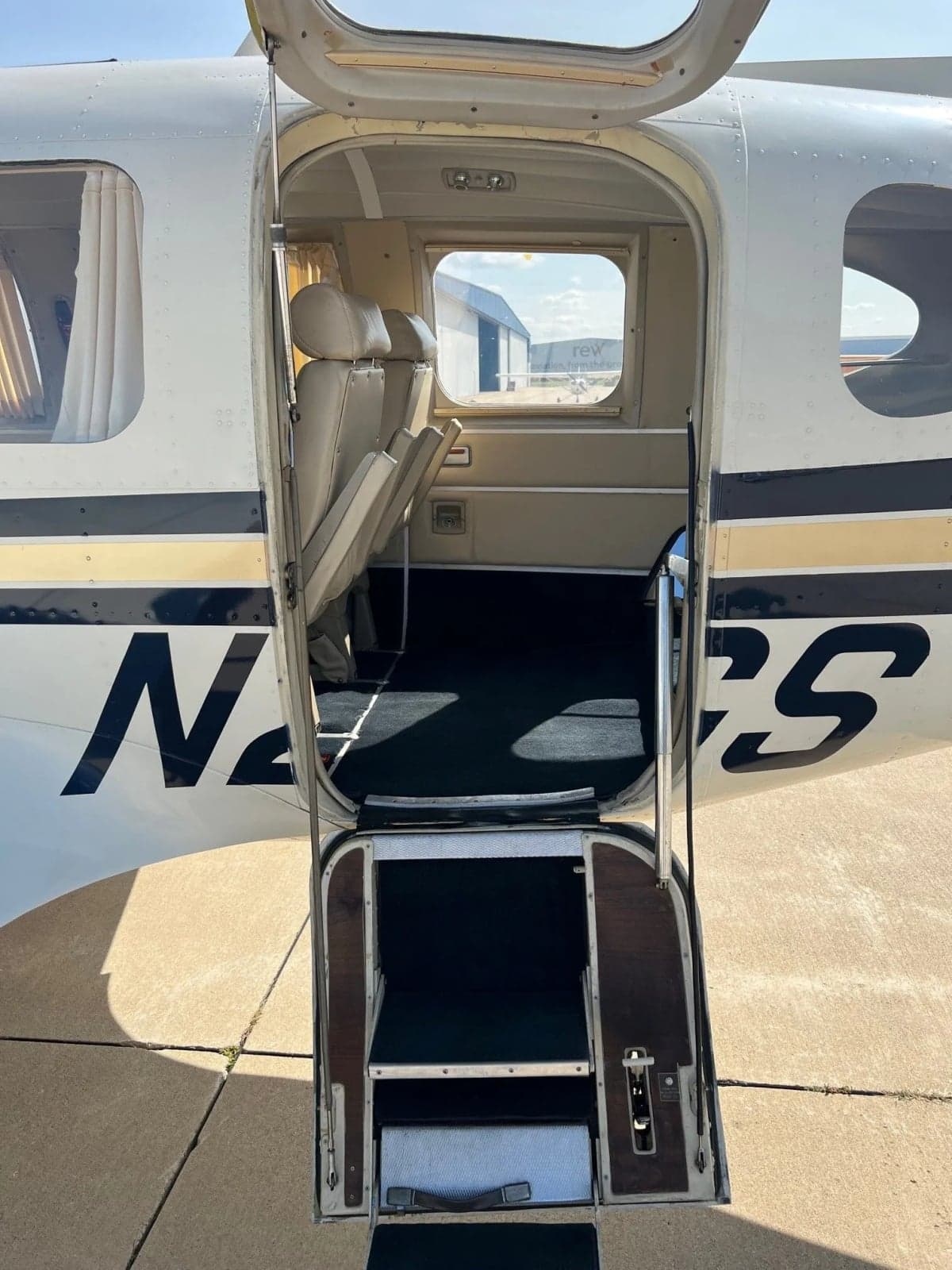 Side view of the N25GS aircraft parked on the tarmac on a sunny day.
