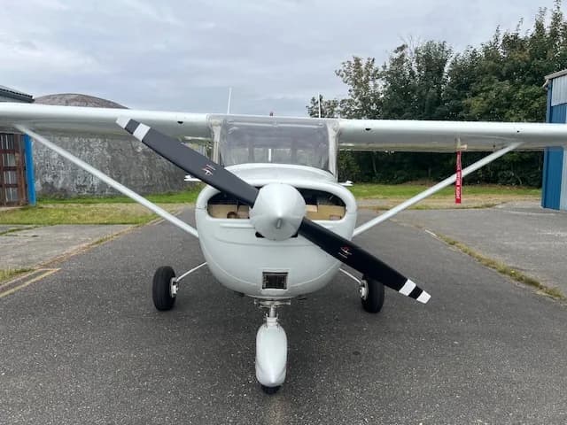 Front view of the C-FZCE Cessna aircraft showing the propeller and landing gear.