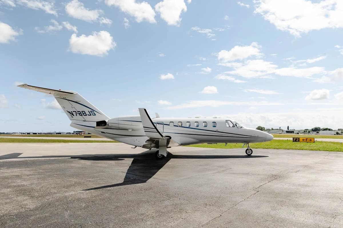 Side view of a white Cessna Citation private jet with registration N788JS parked on the tarmac.