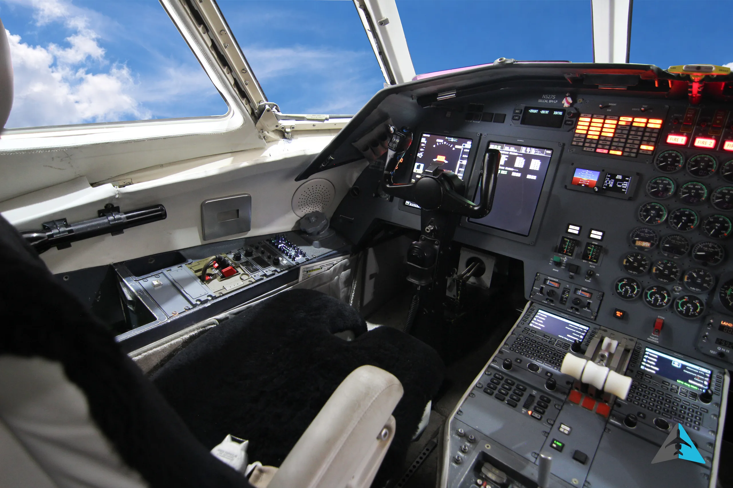 A view of the left side of a business jet cockpit, showing the pilot's controls and instrument panel.