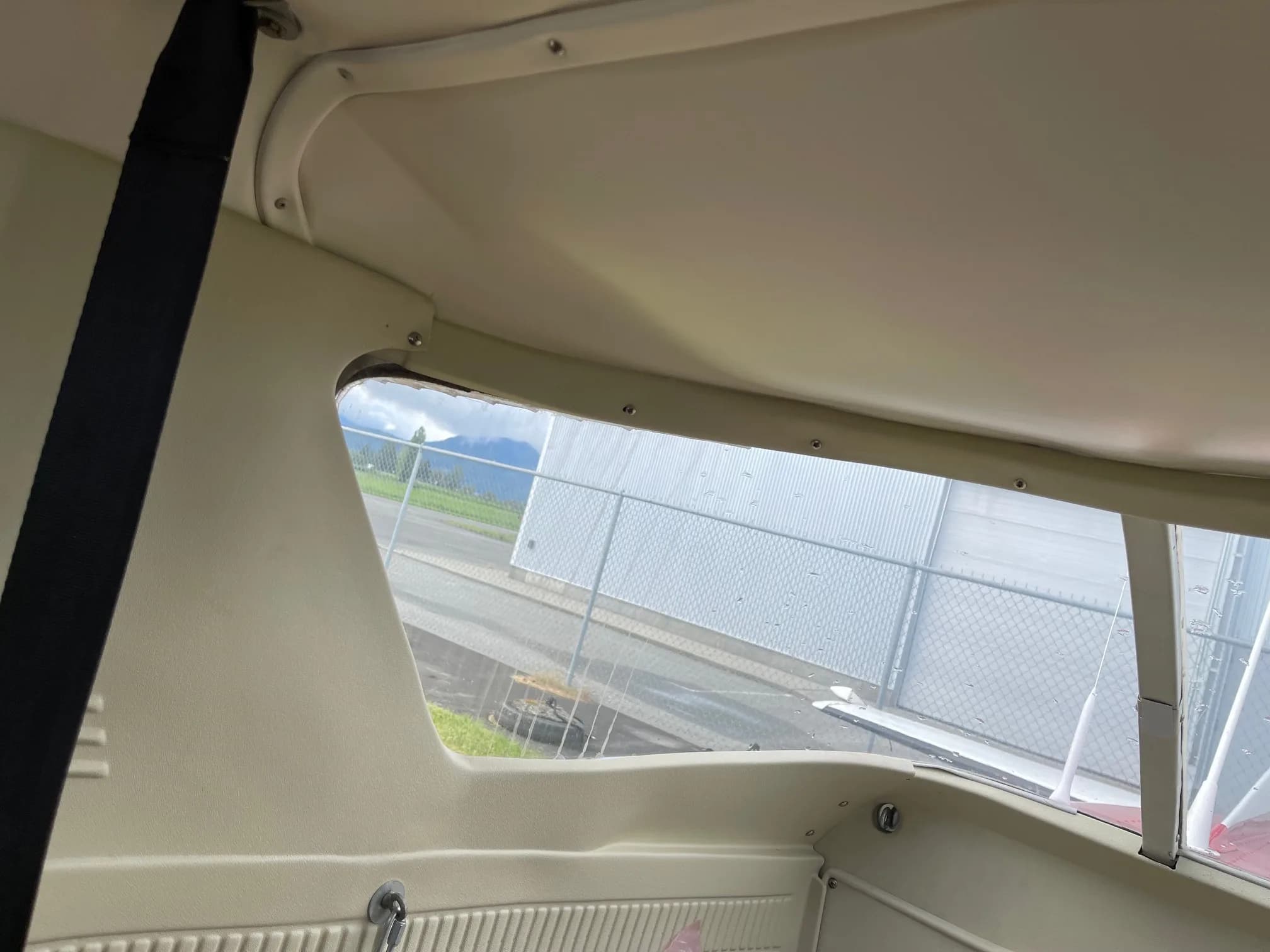 Interior view of the aircraft cabin showing the window and side panel.
