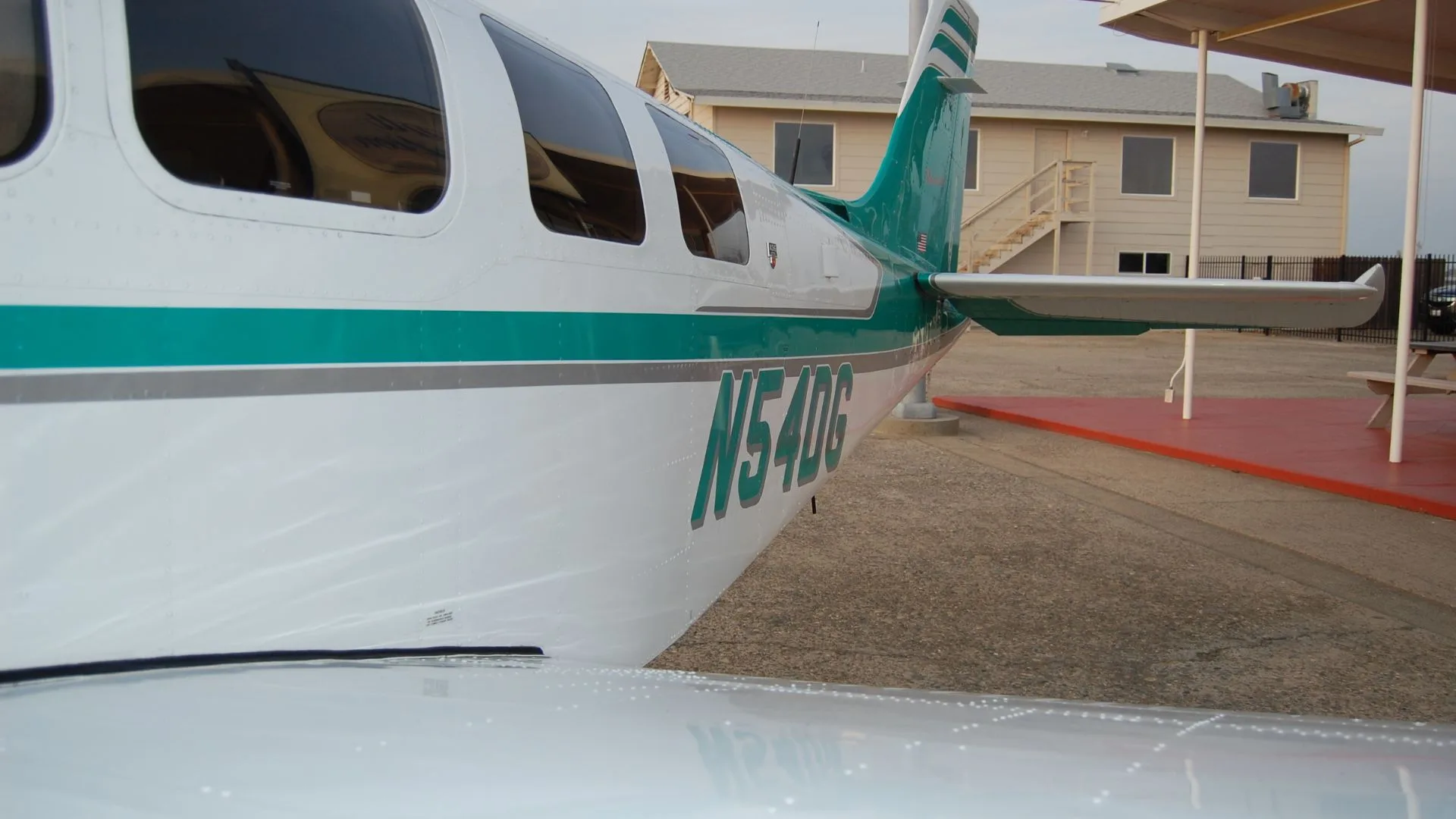 The fuselage of the Beechcraft Bonanza N54DG, showing the teal and white paint scheme and the registration number.