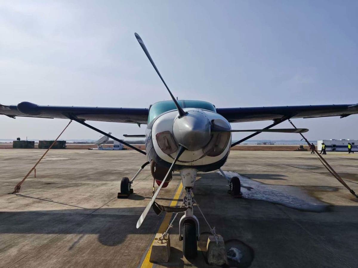 Front view of a blue aircraft parked on the tarmac.