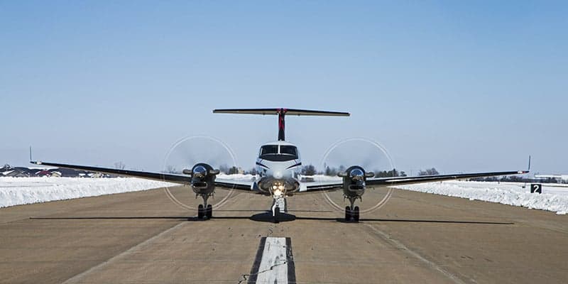 Front view of a King Air 350 on a runway in winter.