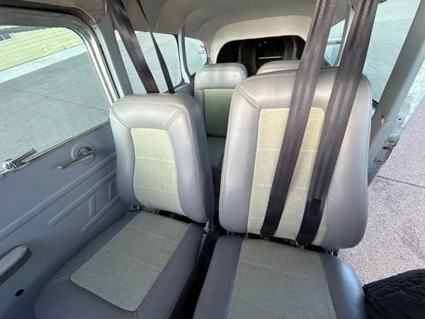Interior of a Cessna 185 Skywagon showing the seats and seatbelts.